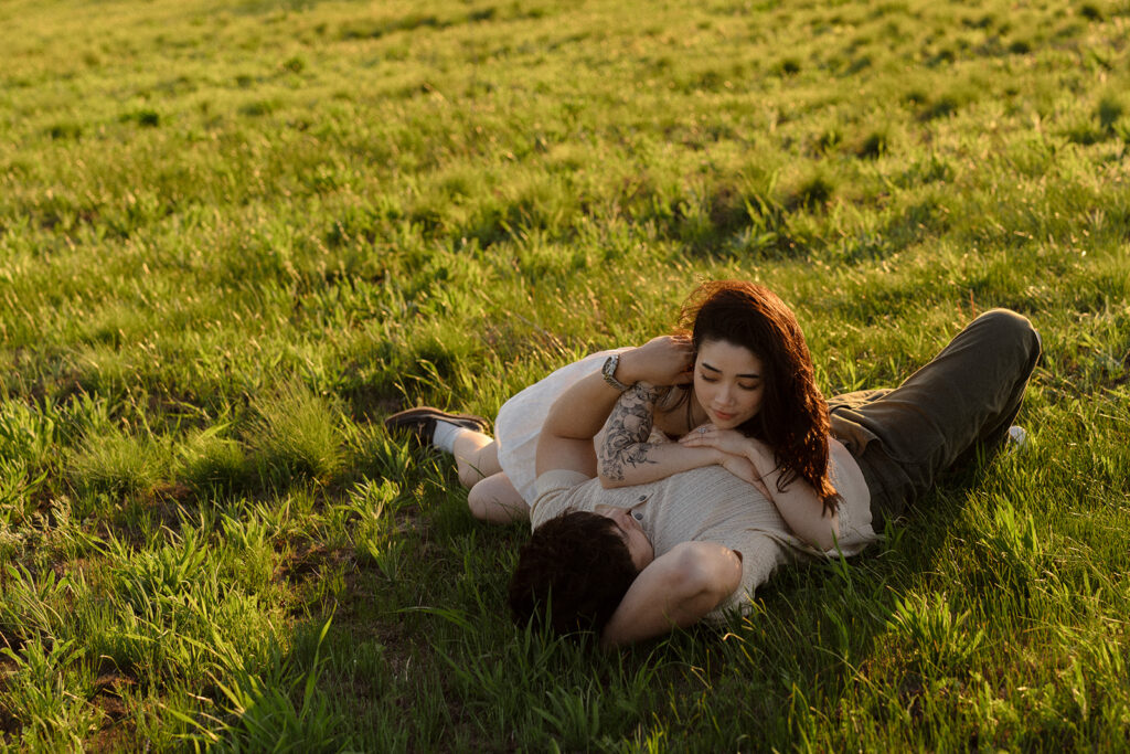 Couple lying in the grass sharing an intimate moment