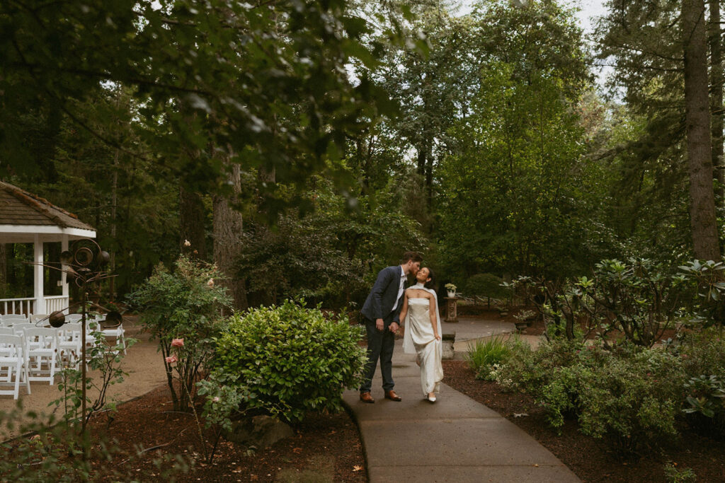 Couple shares a kiss on a winding path near a gazebo