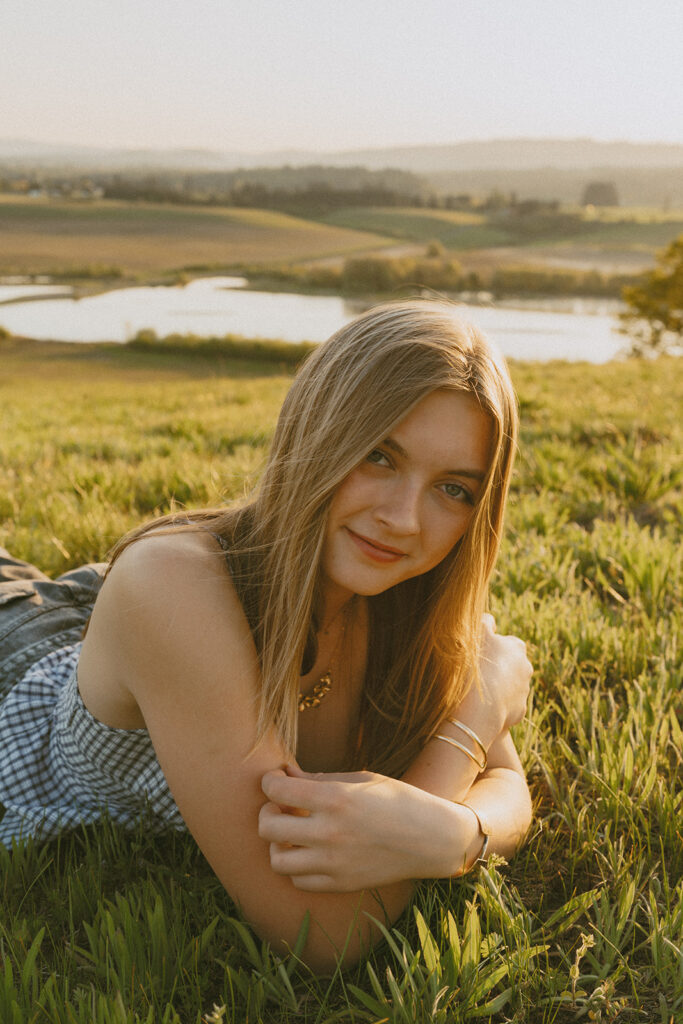 Woman lying in the grass, smiling with her head resting on her arm