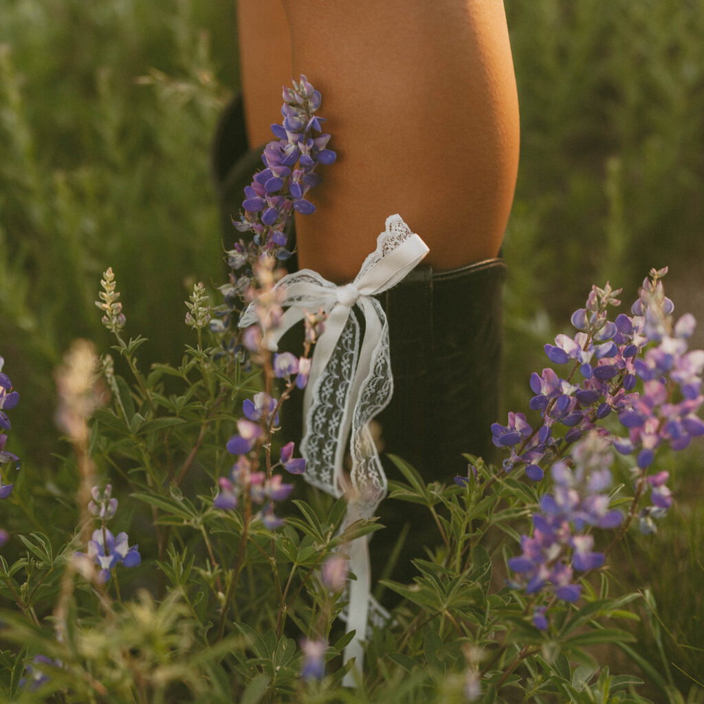 A woman is standing in a field of purple flowers.