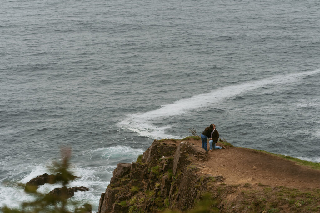 Couple sharing a kiss during a beach proposal