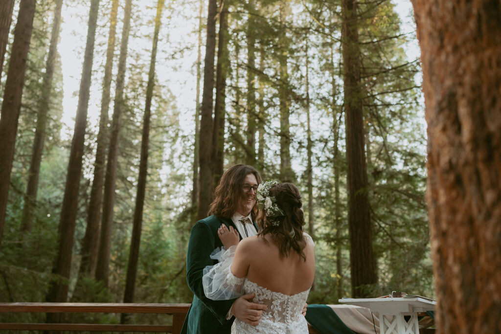 Close-up of the couple smiling and embracing among tall trees