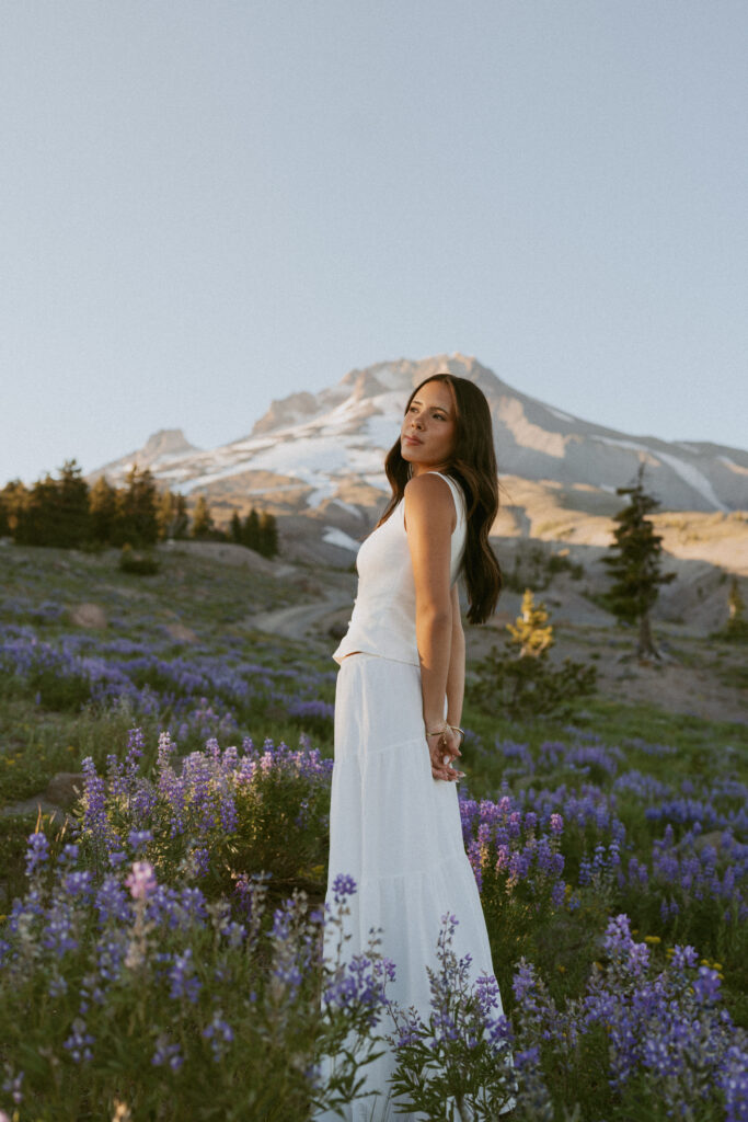Woman in white dress among purple lupines at Mt Hood