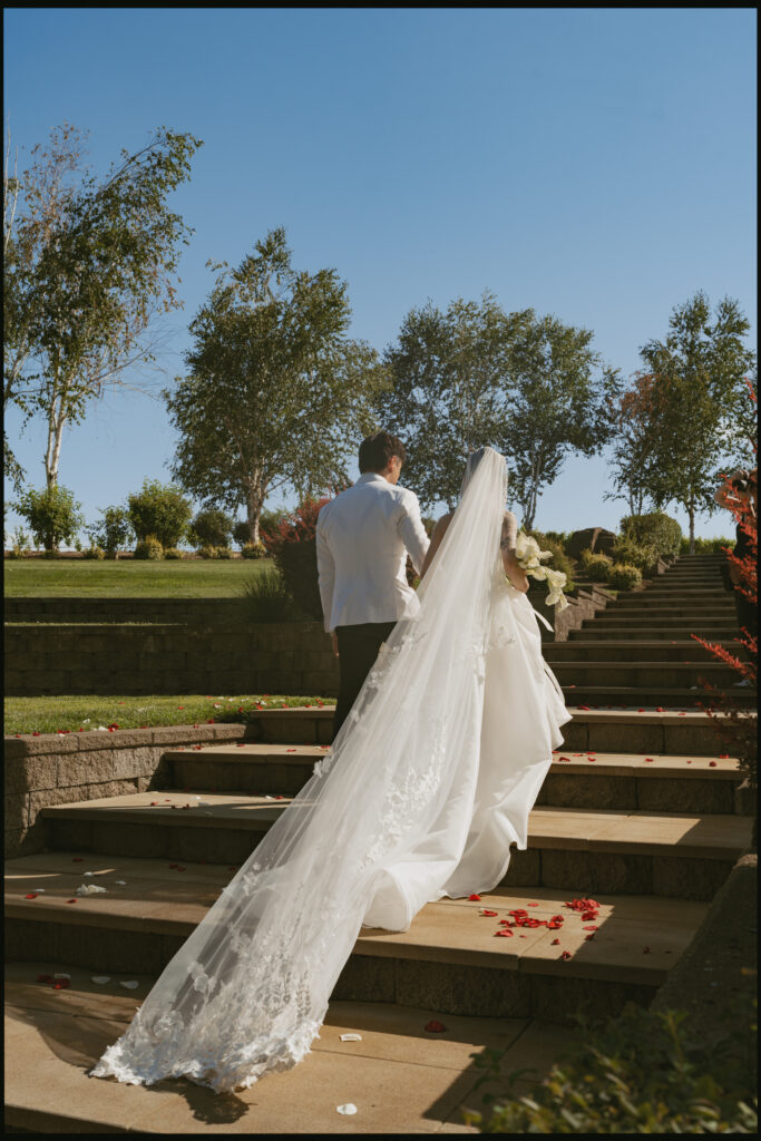 Bride climbs wooden steps with flowing veil
