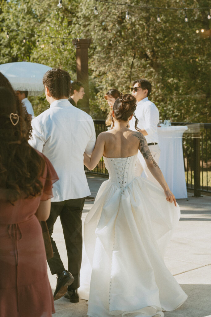 Bride walks with groom from outdoor ceremony of their micro wedding