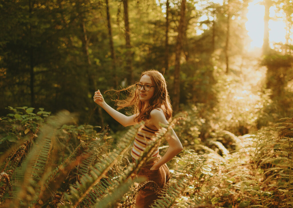 Woman with glasses holds leaf in golden light in Portland 