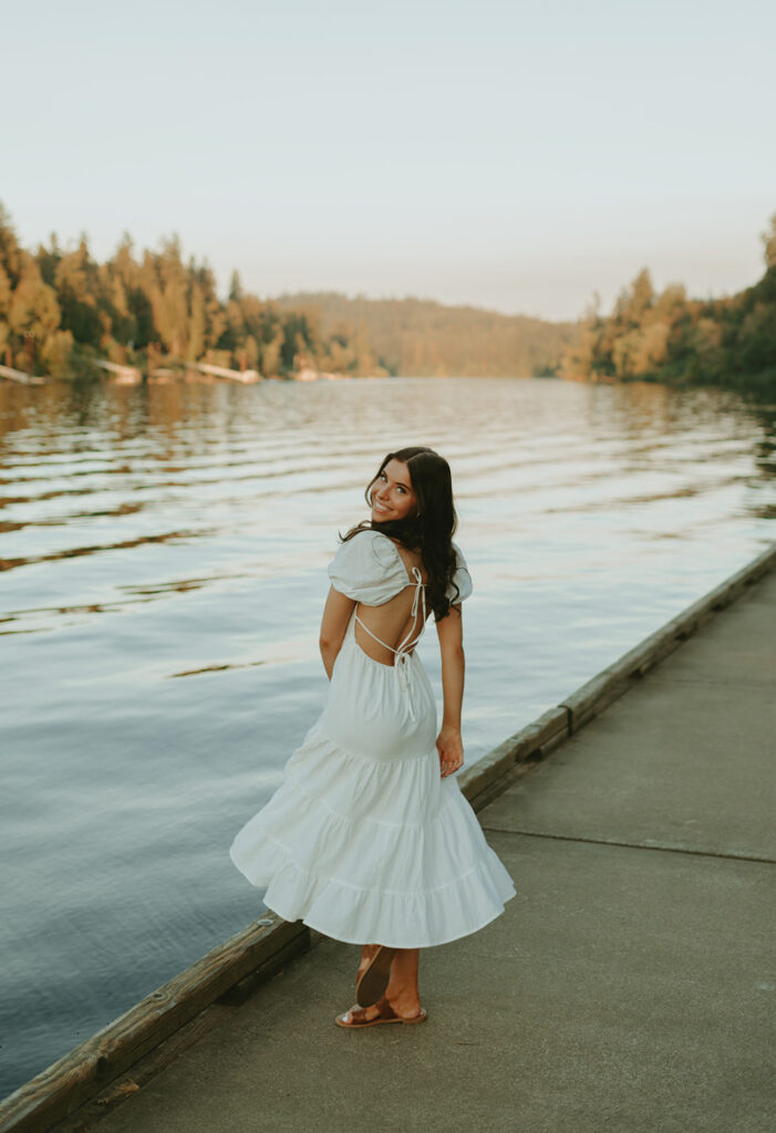 Woman in white dress on lake dock in coastal Oregon