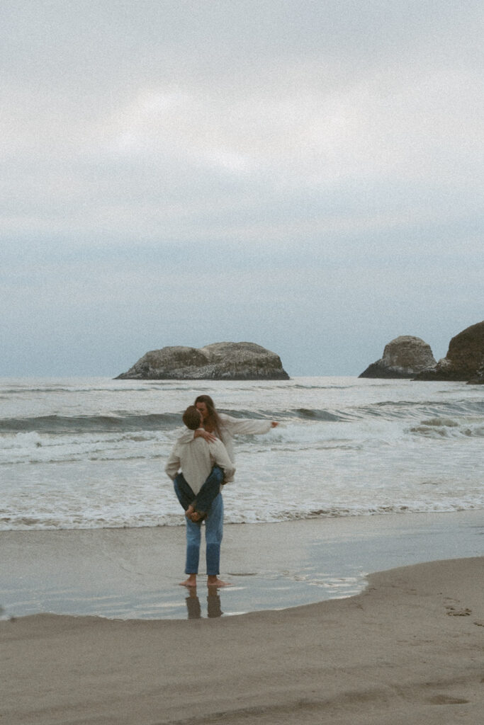 Man lifts woman while standing in the ocean waves