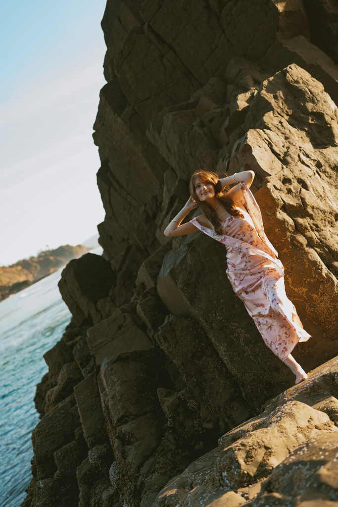 Lady in pink leaning on rock at Oregon Beach