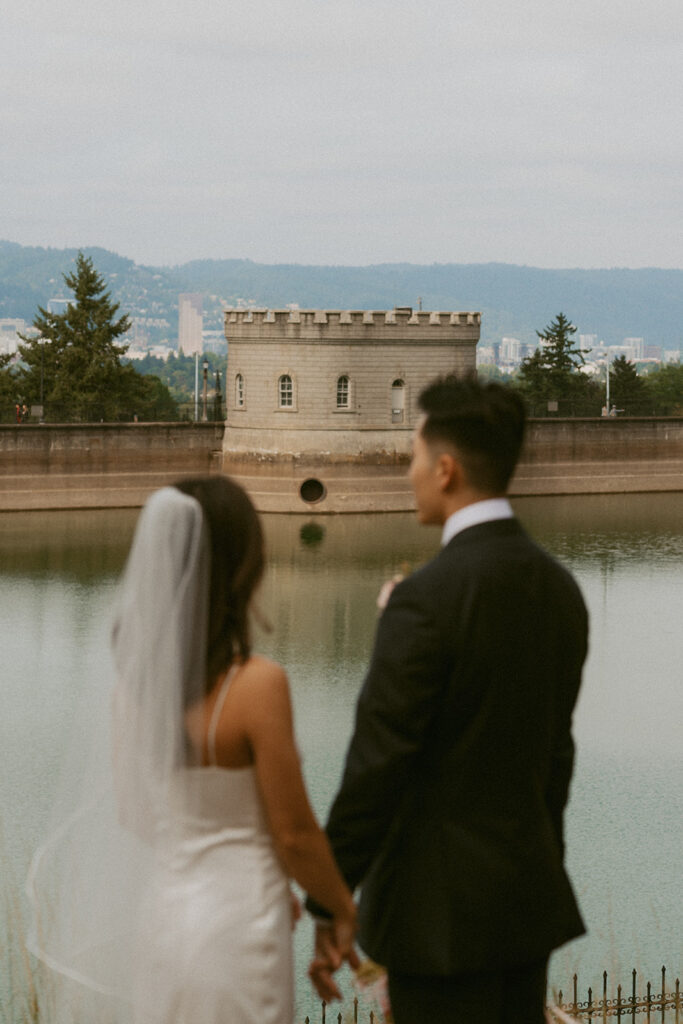 Bride and groom by castle-like water tower Portland Oregon elopement