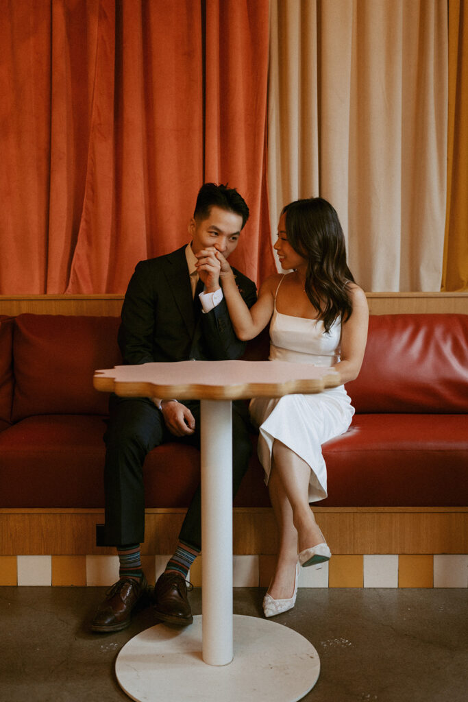 Couple sharing a kiss on the hand at a cozy café