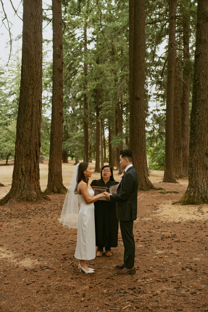 Couple exchanging vows in the forest during their Portland Oregon elopement