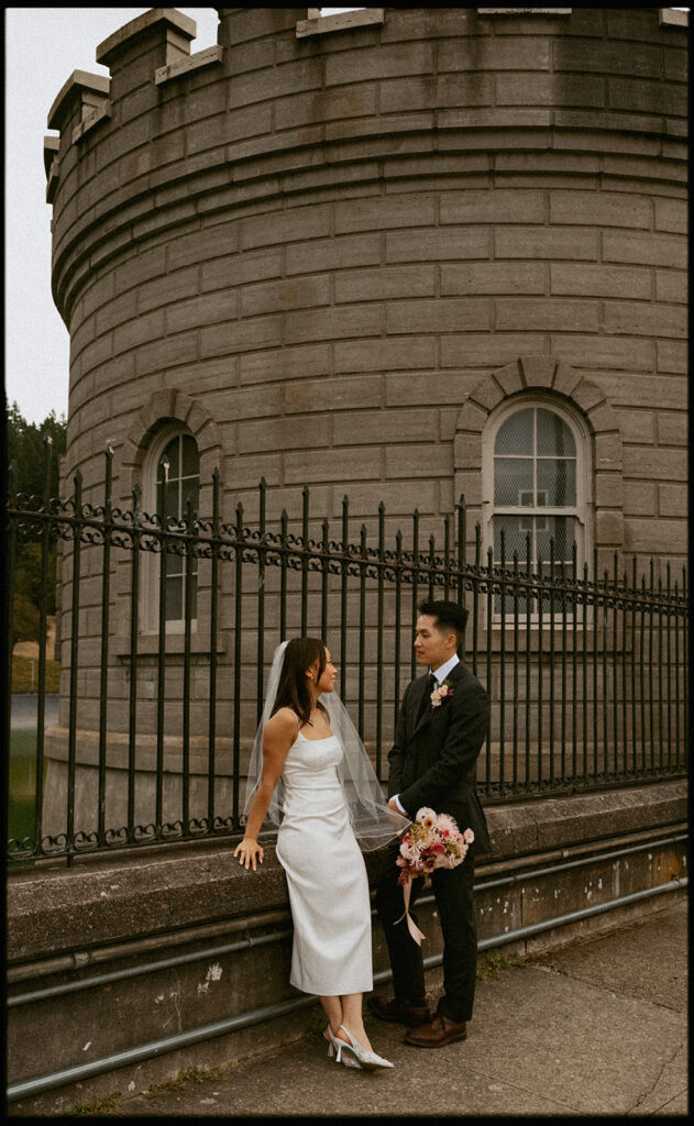 Couple starring each other in front of stone building
