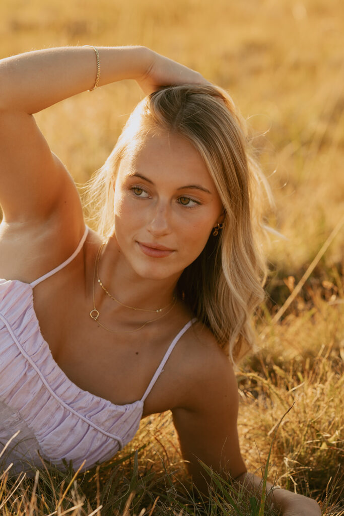 Senior girl in lavender dress posing in field at sunset in Salem Oregon