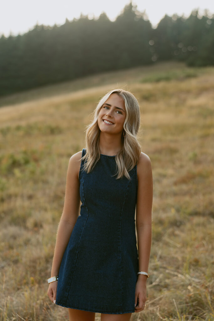 Photography of a girl smiling in a denim dress in a field