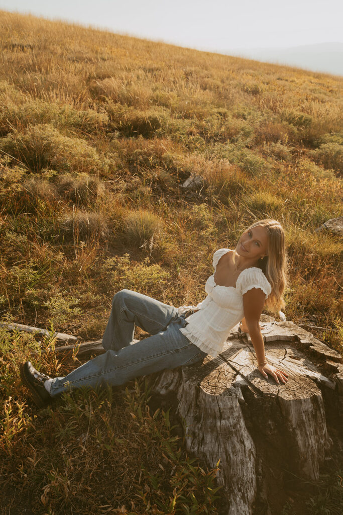 Salem Oregon senior photography sitting on tree stump in golden light