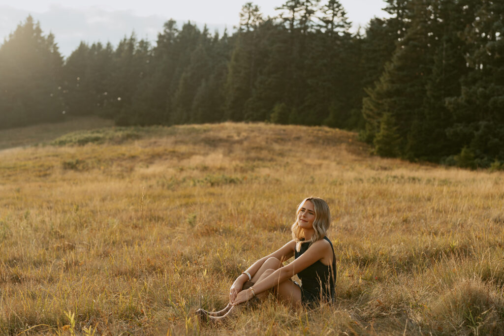 Girl sitting in a meadow at golden hour