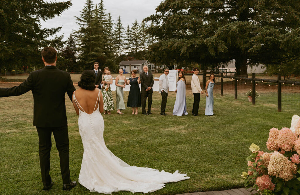 Couple greeting guests at backyard reception
