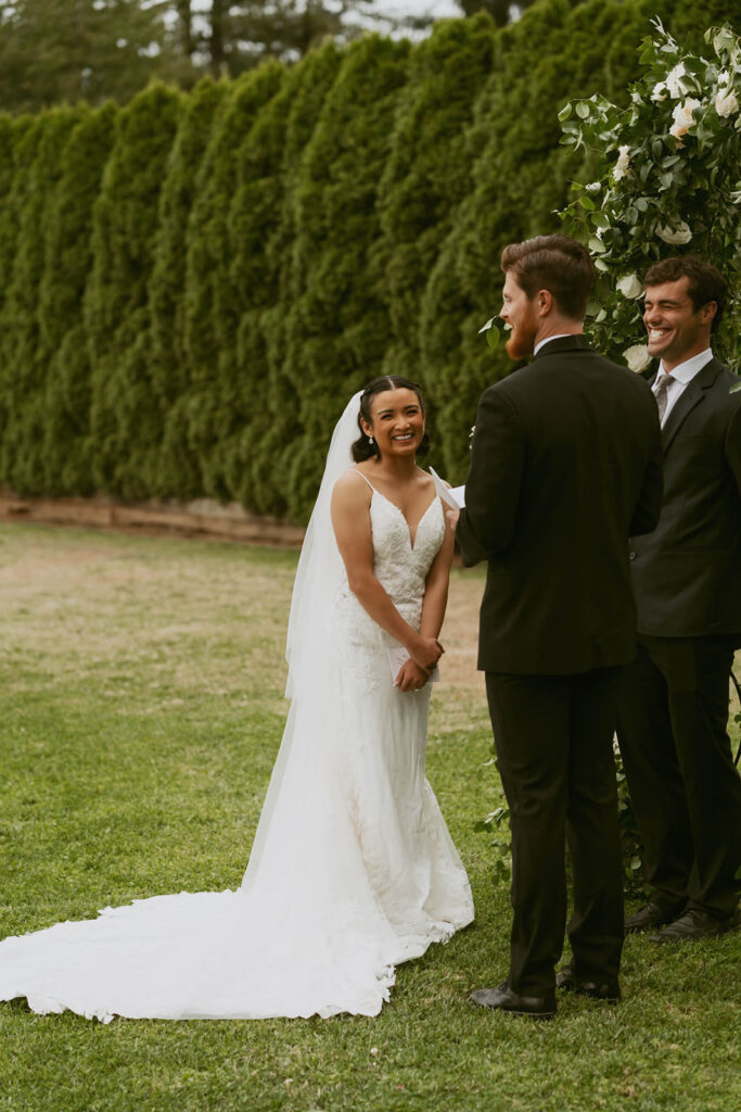 Bride smiling at groom during outdoor ceremony
