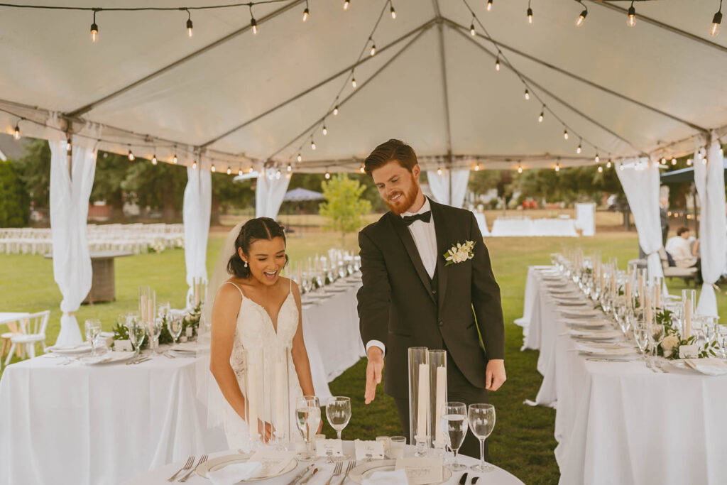 Couple smiling under wedding tent lights