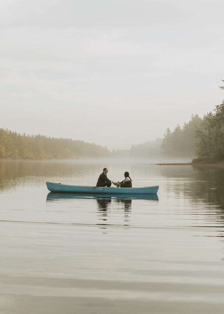 Couple in canoe on misty Oregon lake during intimate elopement