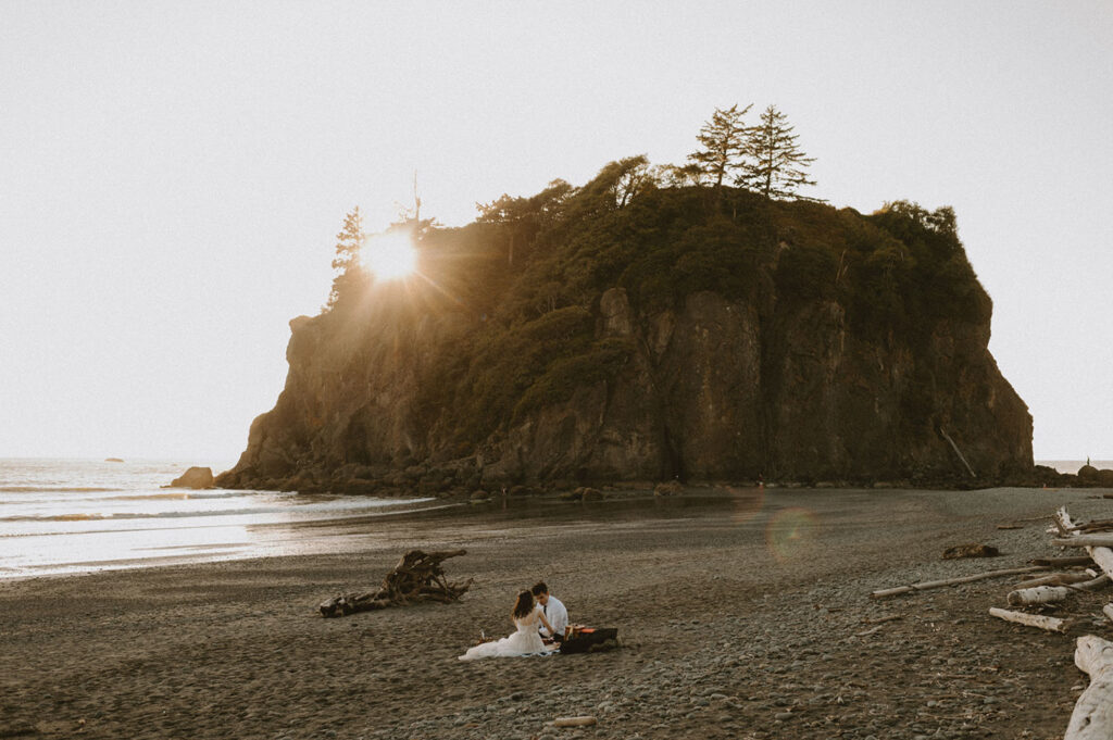 Couple enjoying picnic on Oregon beach at sunset