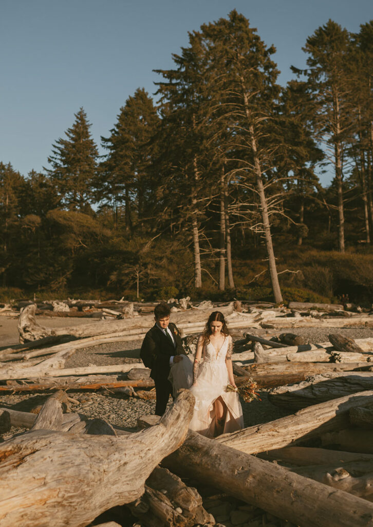 Couple exploring driftwood along the Oregon coastline