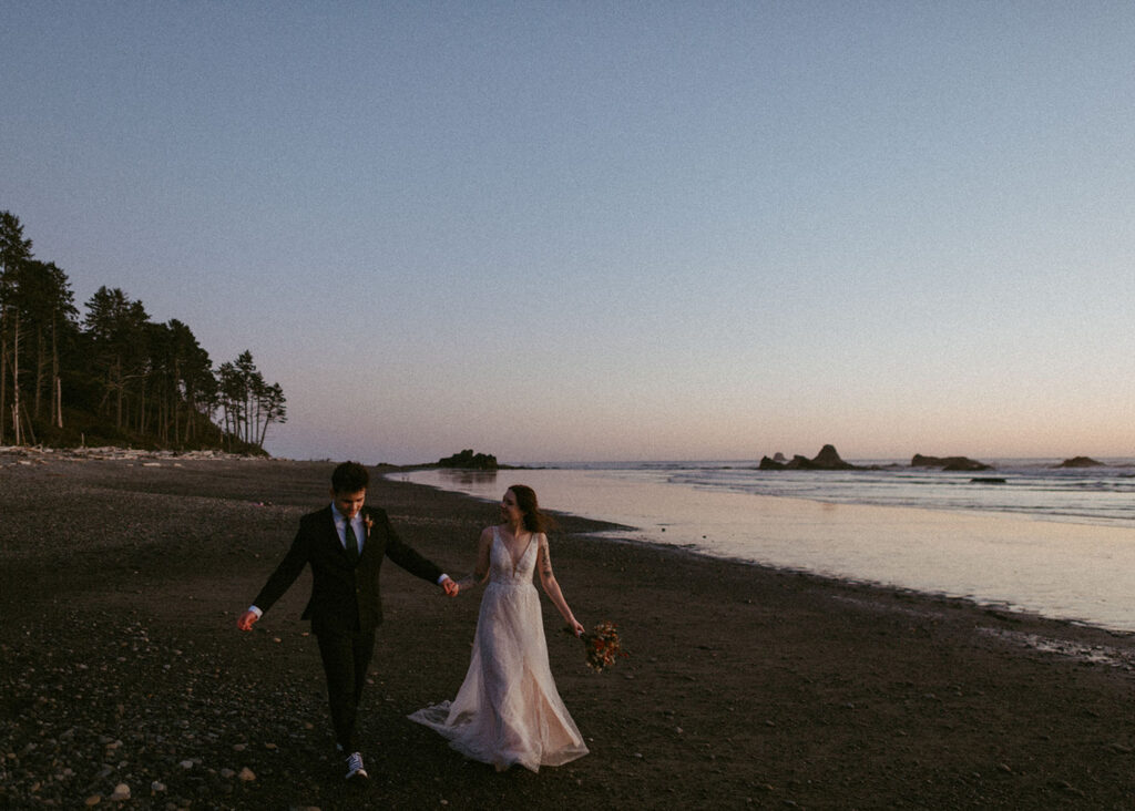 Bride and groom smiling and holding hands during Oregon beach elopement