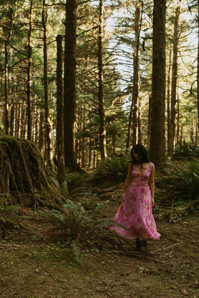 Woman in pink floral dress walking through forest