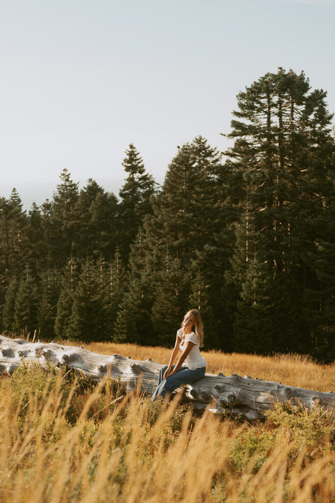 Senior sitting down on a log during her Salem Senior photo session