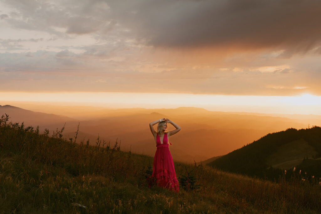 A senior girl poses at sunset on a mountain ridge captured by a Salem senior photographer