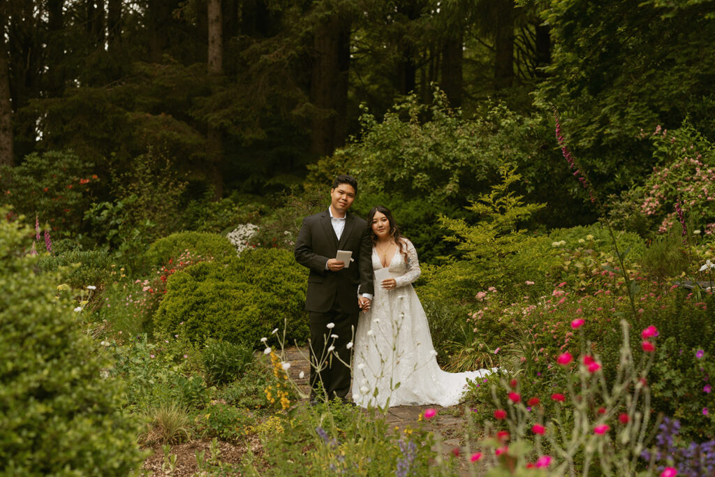 Bride and groom standing together in a blooming garden