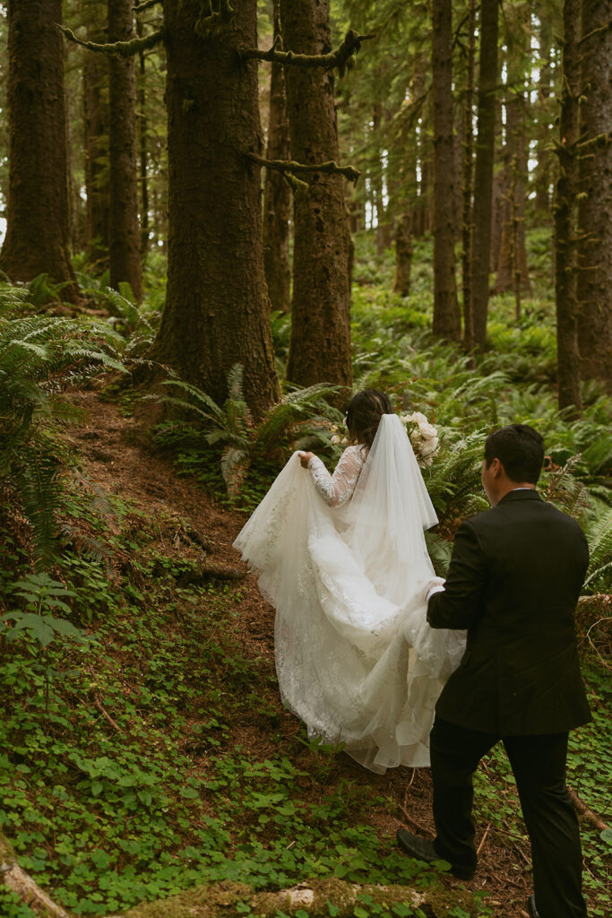 Couple walking down a wooden walkway in the trees.
