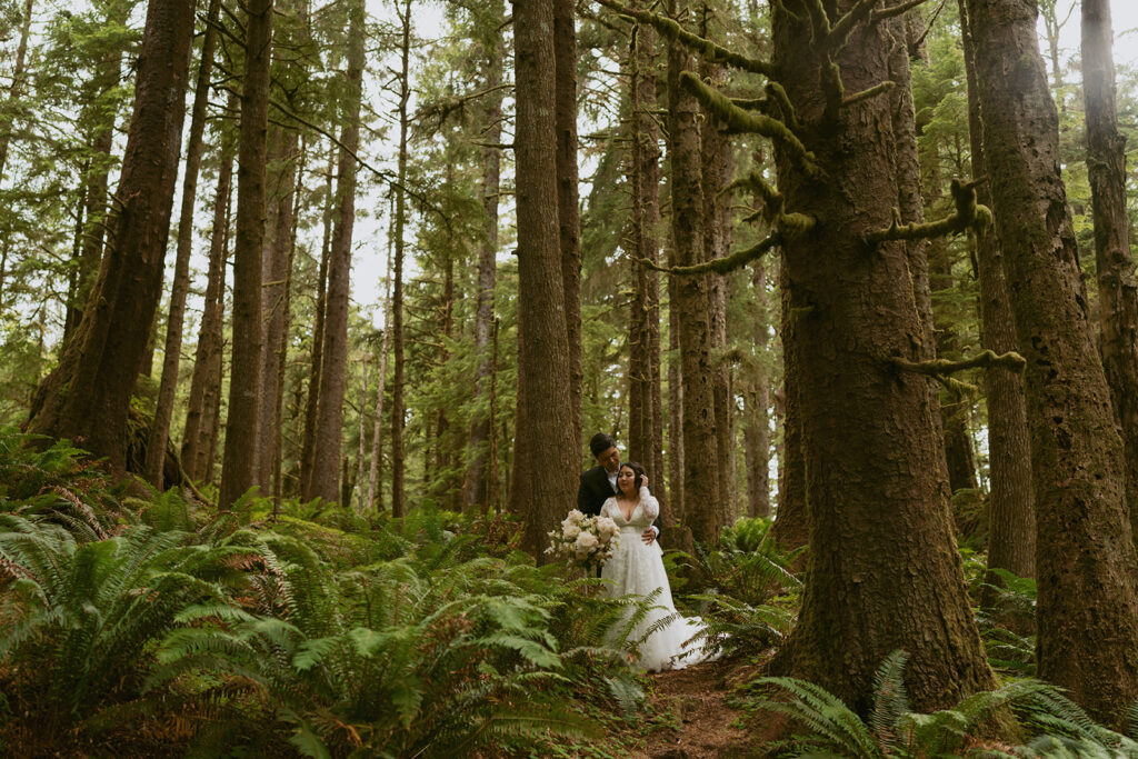 Couple in a forest clearing among tall trees