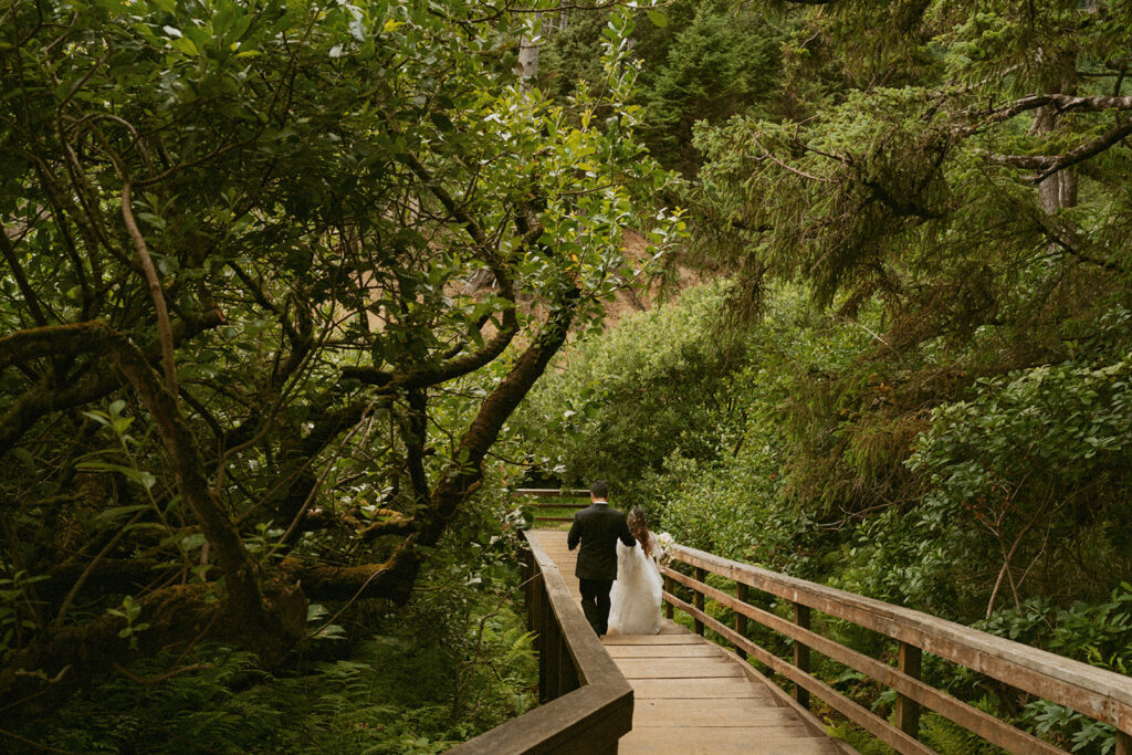 Bride and groom walking on a forest boardwalk