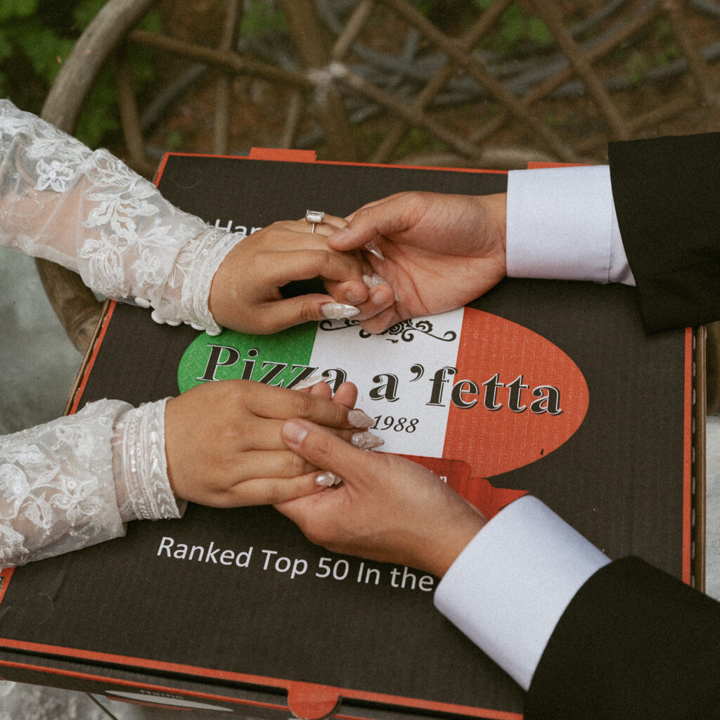 Close-up of wedding rings over a Pizza a’fetta box