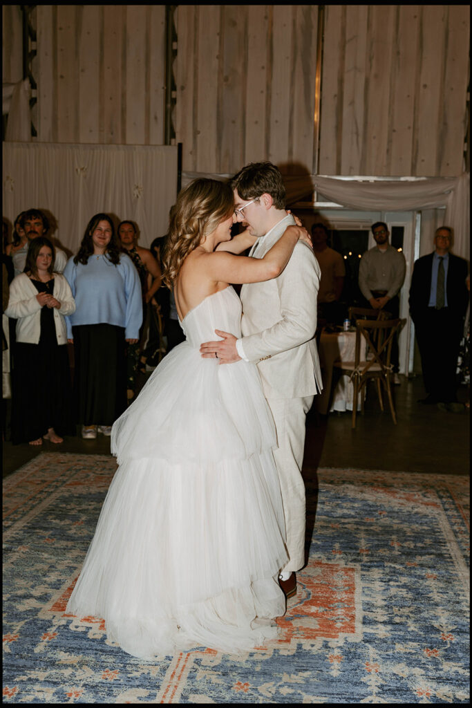 Couple sharing first dance with guests watching