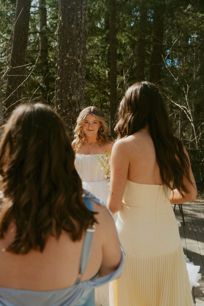 Bride meeting bridesmaids outdoors, forest wedding setting