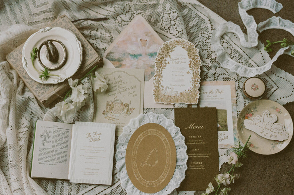 Flat lay of wedding stationery with lace and florals
