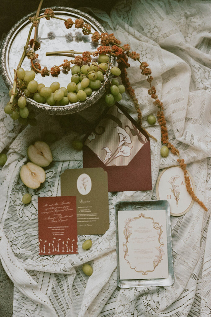 Flat lay of invitations with grapes and vintage tray