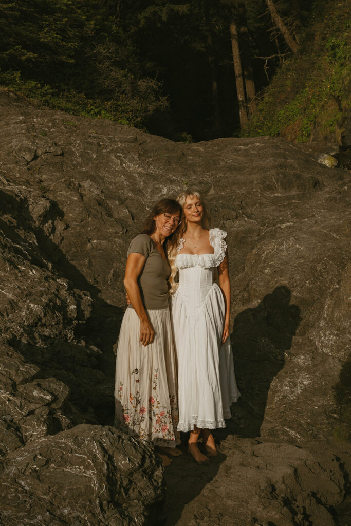 Senior posing with another woman by the rocks