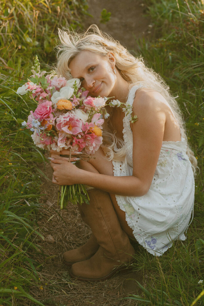 Senior holding a colorful bouquet in the grass