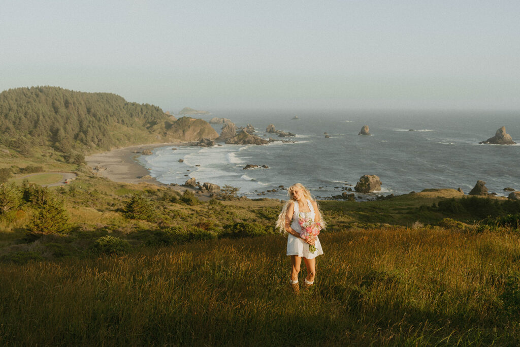 Senior standing in a coastal meadow with bouquet