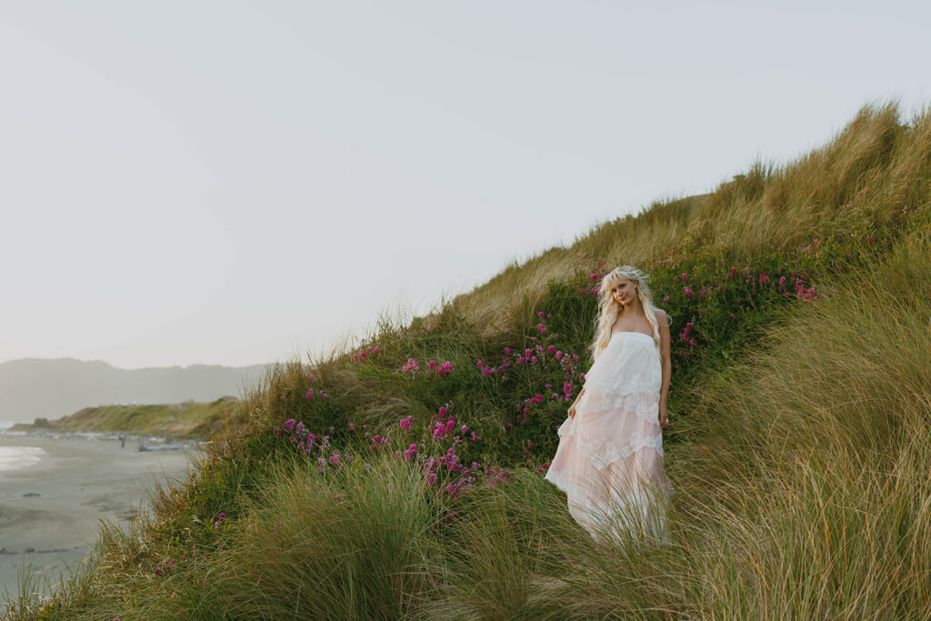Senior posing among coastal wildflowers