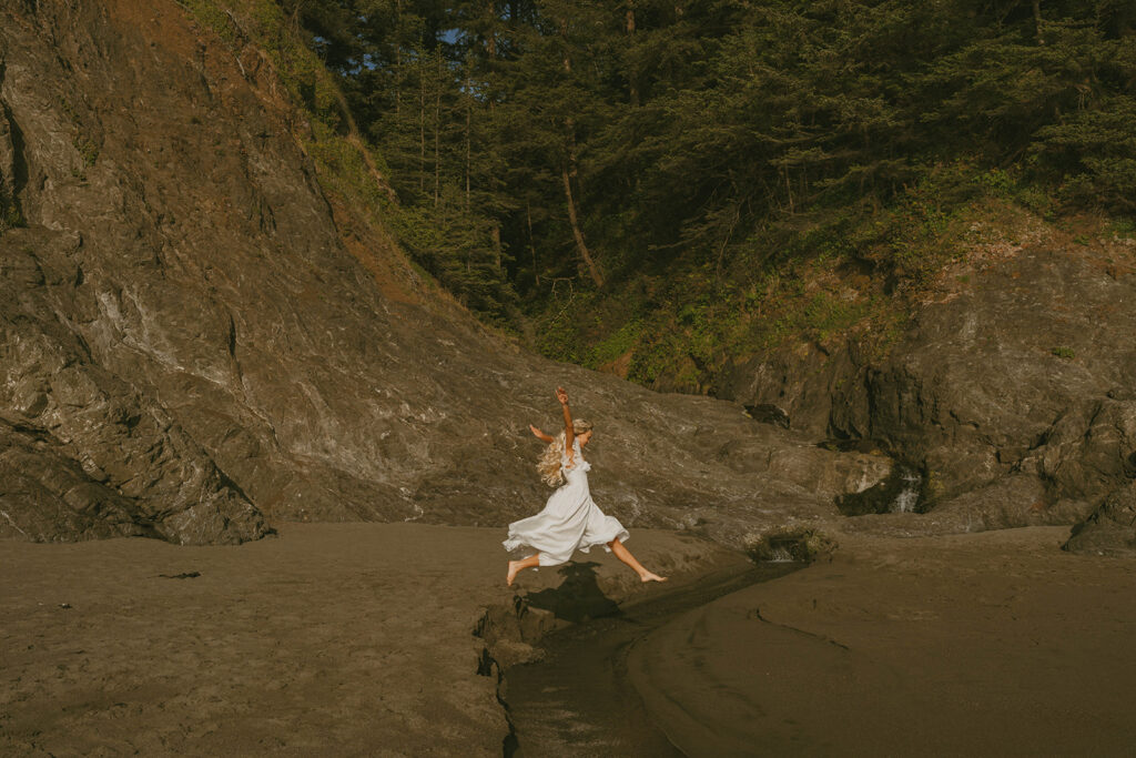 Senior jumping on a rocky beach