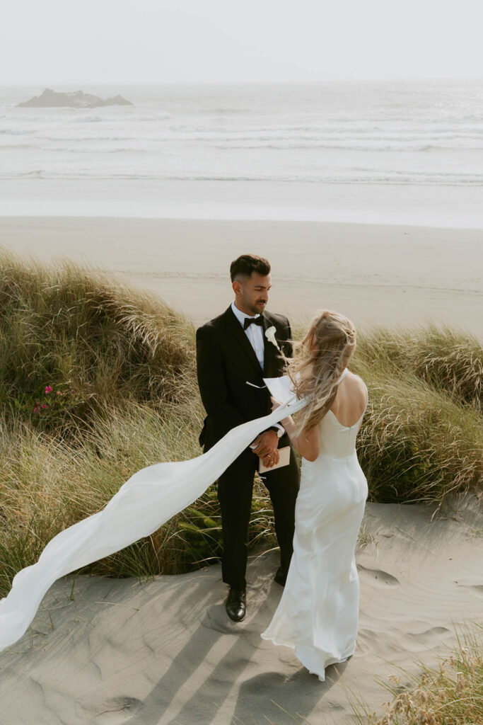 Couple holding hands on a sandy dune path