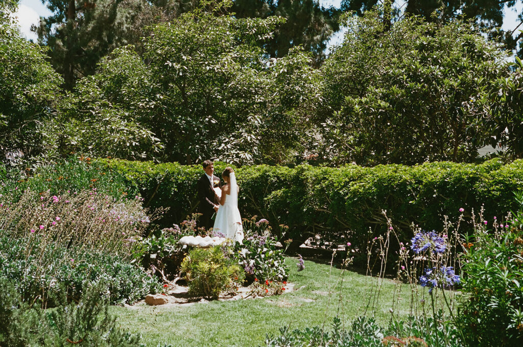 Couple standing together in a lush garden
