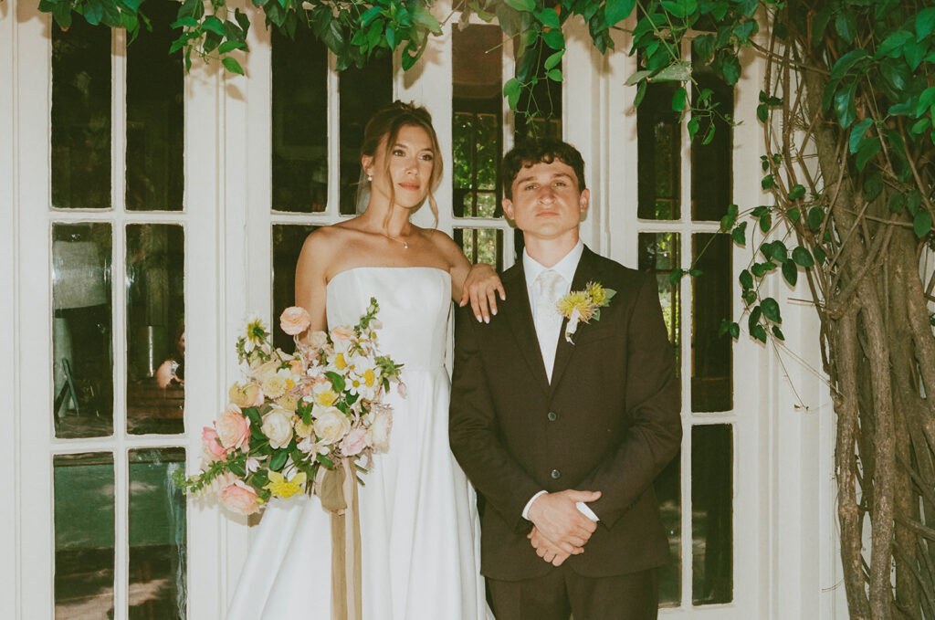 Couple posing with a colorful floral bouquet