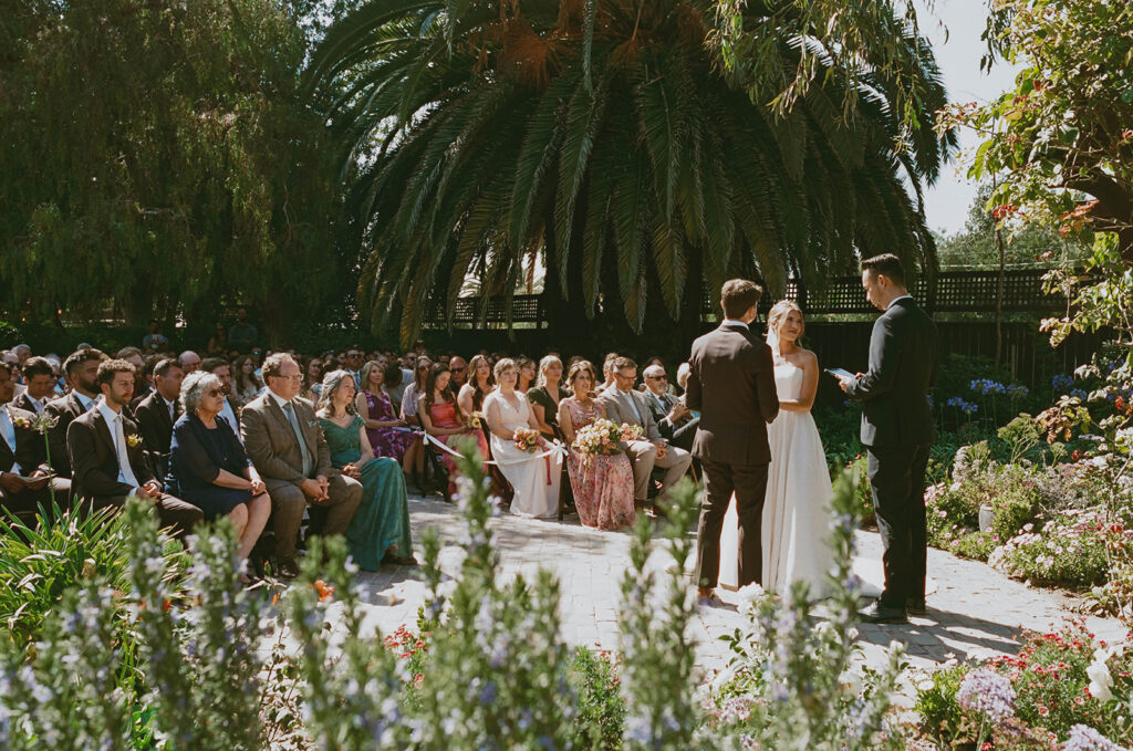 Garden wedding ceremony with seated guests