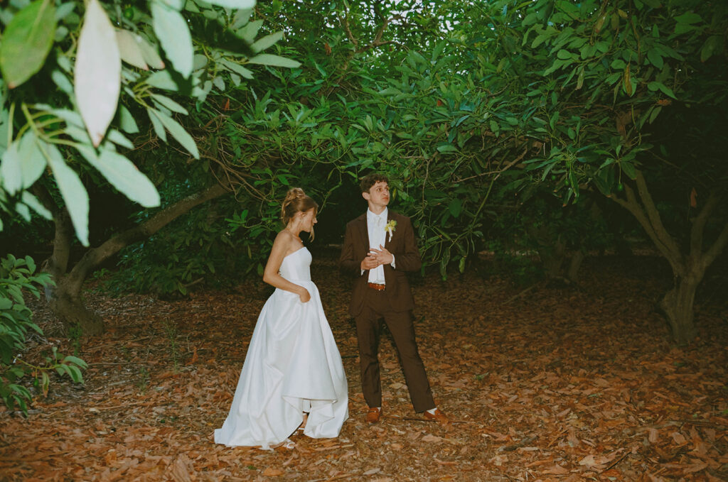 Couple standing beneath dense garden greenery